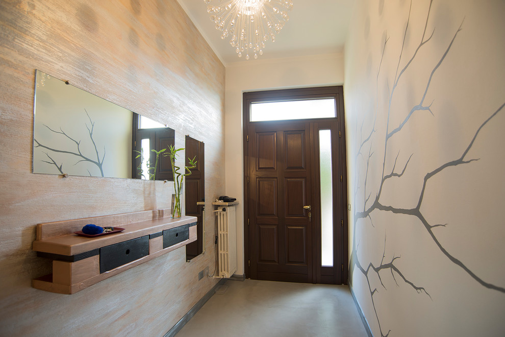 Idée de décoration pour une entrée minimaliste de taille moyenne avec un couloir, un mur multicolore, sol en béton ciré, une porte simple, une porte marron et un sol gris.
