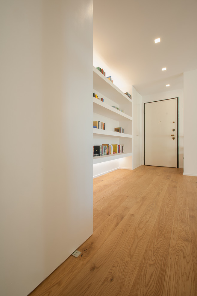 Inspiration for a mid-sized contemporary light wood floor and white floor entryway remodel in Milan with white walls and a white front door