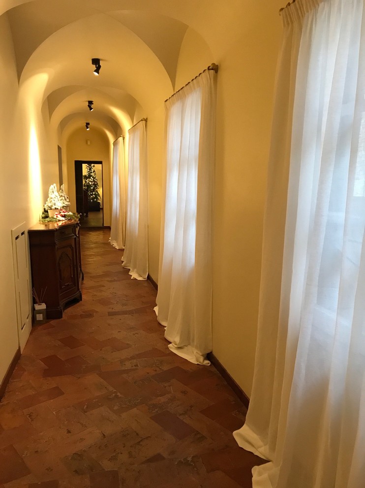 ローマにある広いトラディショナルスタイルのおしゃれな廊下 (白い壁、テラコッタタイルの床) の写真