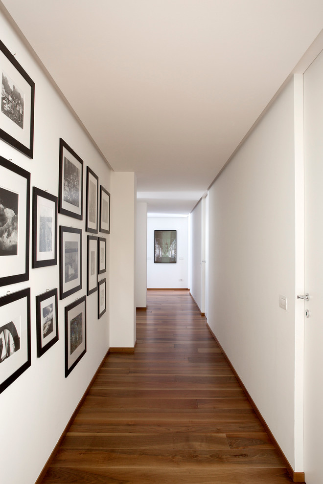 На фото: коридор среднего размера в современном стиле с белыми стенами и темным паркетным полом