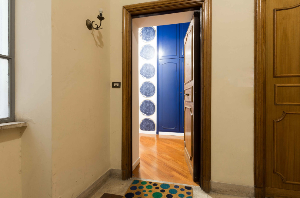 Inspiration for a modern entrance in Rome with light hardwood flooring and wallpapered walls.