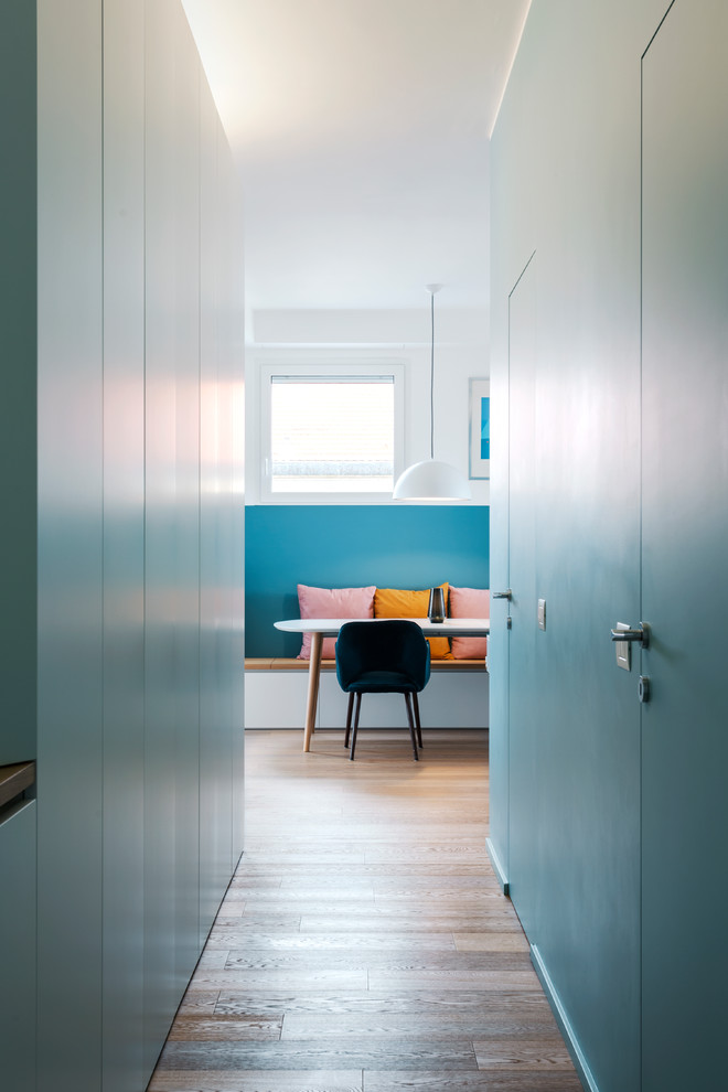 Immagine di un piccolo ingresso o corridoio design con pareti blu e pavimento in legno massello medio