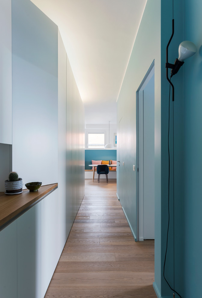 Ispirazione per un piccolo ingresso o corridoio design con pareti blu e pavimento in legno massello medio