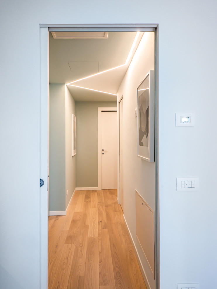 Cette image montre un petit couloir design avec un mur vert, parquet clair et un plafond décaissé.