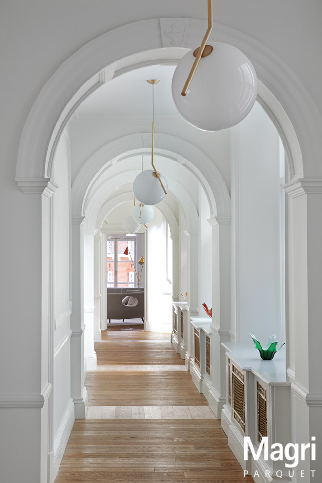 На фото: коридор в стиле неоклассика (современная классика) с белыми стенами с