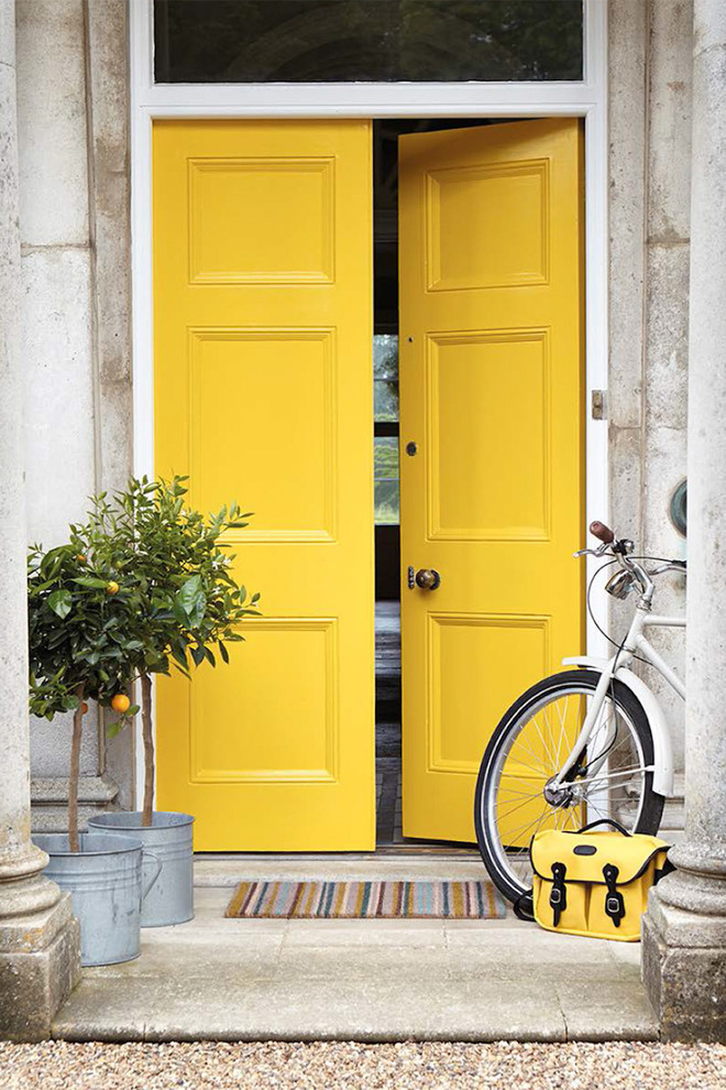 Idée de décoration pour une entrée méditerranéenne avec une porte double et une porte jaune.