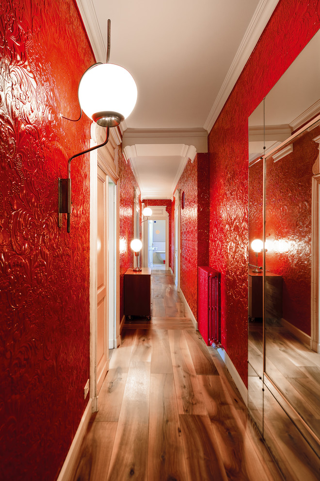 Foto de recibidores y pasillos contemporáneos con paredes rojas y suelo de madera en tonos medios