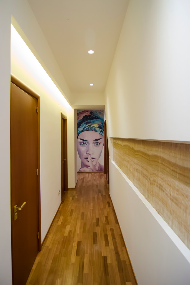 Foto di un piccolo ingresso o corridoio contemporaneo con pareti bianche e pavimento in legno massello medio