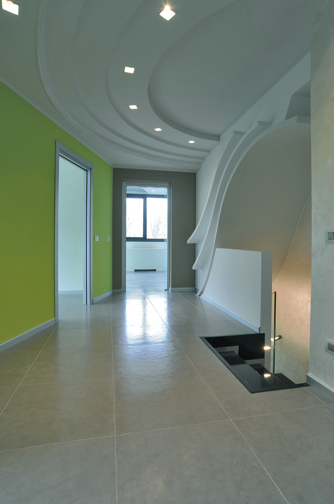 Стильный дизайн: большой коридор в стиле лофт с серыми стенами и полом из керамогранита - последний тренд