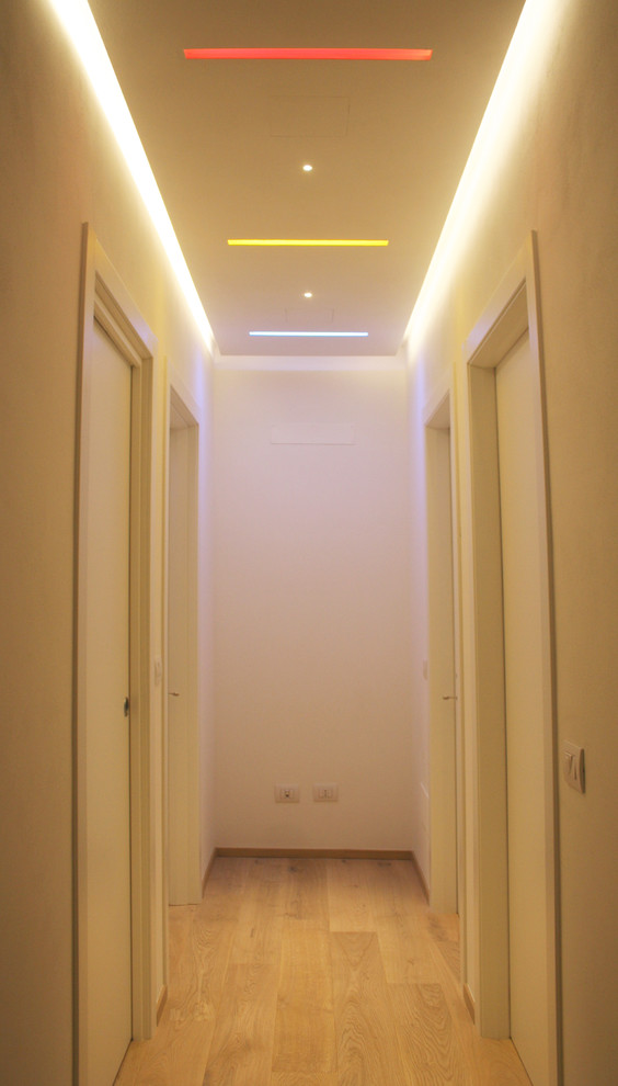 На фото: коридор в современном стиле с белыми стенами и светлым паркетным полом с