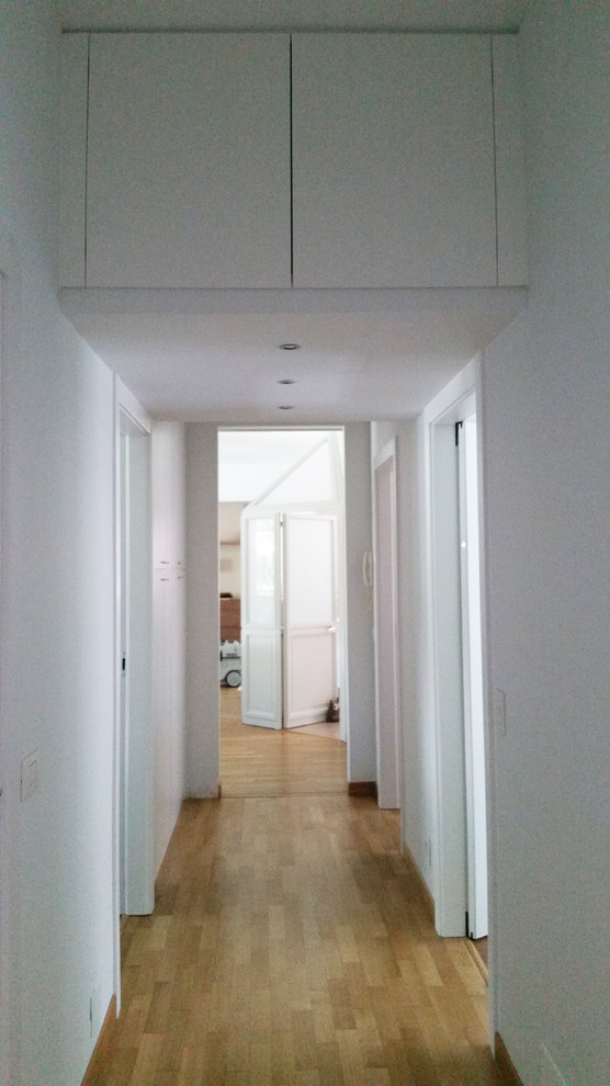 На фото: коридор среднего размера в современном стиле с белыми стенами, светлым паркетным полом и бежевым полом с