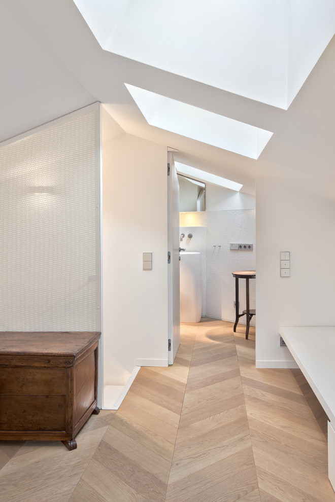 Example of a large trendy light wood floor hallway design in Milan with white walls