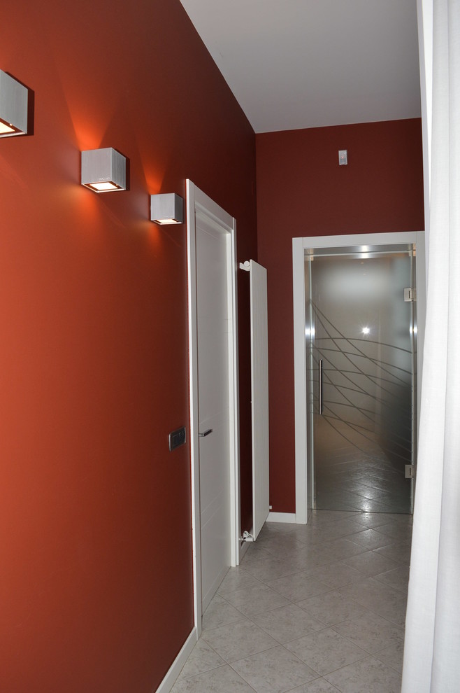 Esempio di un piccolo ingresso o corridoio minimalista con pareti rosse, pavimento in gres porcellanato e pavimento grigio