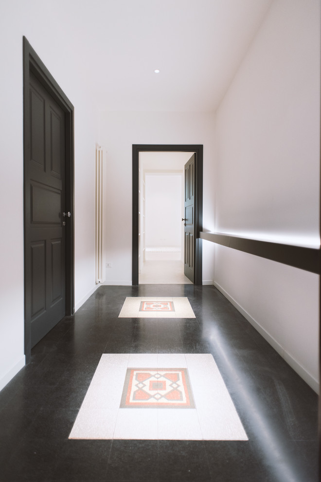 Стильный дизайн: коридор среднего размера с белыми стенами, полом из терраццо и черным полом - последний тренд