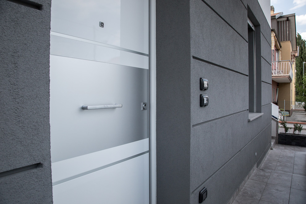 Idee per una porta d'ingresso design di medie dimensioni con pareti bianche, pavimento in gres porcellanato, una porta singola, una porta in metallo e pavimento grigio