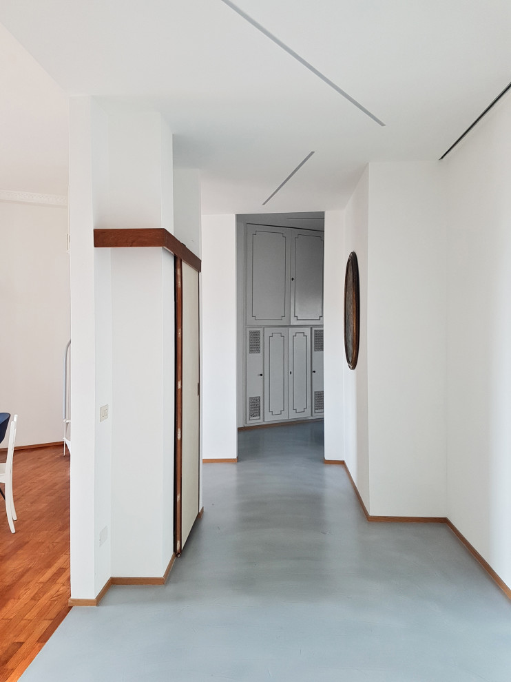 Idee per un ingresso o corridoio minimalista con pareti bianche e pavimento turchese