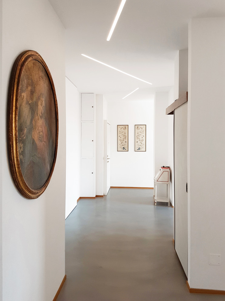 Ispirazione per un ingresso o corridoio minimalista con pareti bianche e pavimento turchese