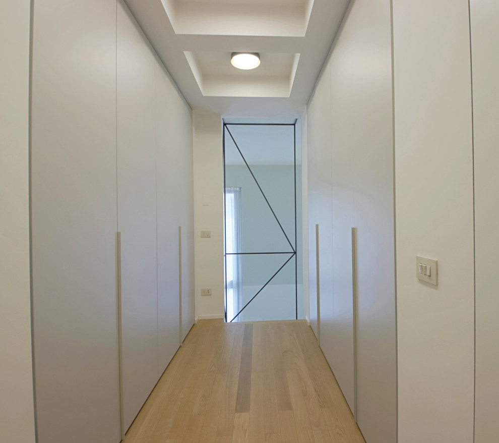 Esempio di un piccolo ingresso o corridoio industriale con pareti bianche, parquet chiaro e soffitto ribassato
