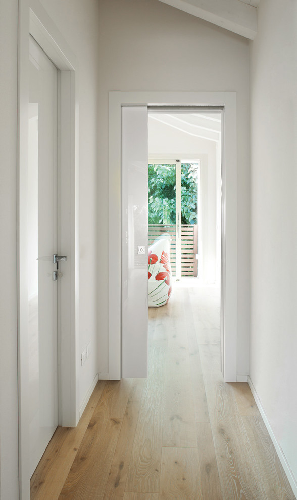 Ispirazione per un piccolo ingresso o corridoio design con pareti bianche, parquet chiaro e pavimento beige