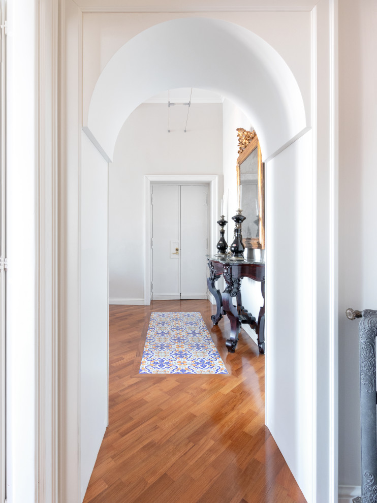 Photo of a large modern foyer in Naples with white walls and dark hardwood flooring.