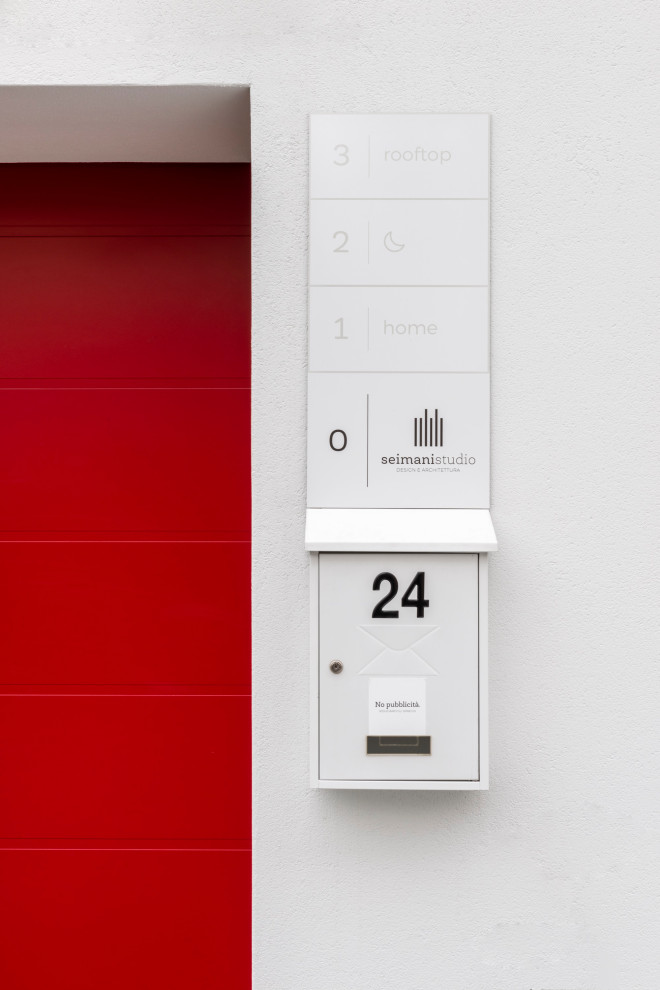 Esempio di una porta d'ingresso minimal con pareti bianche, una porta singola e una porta rossa