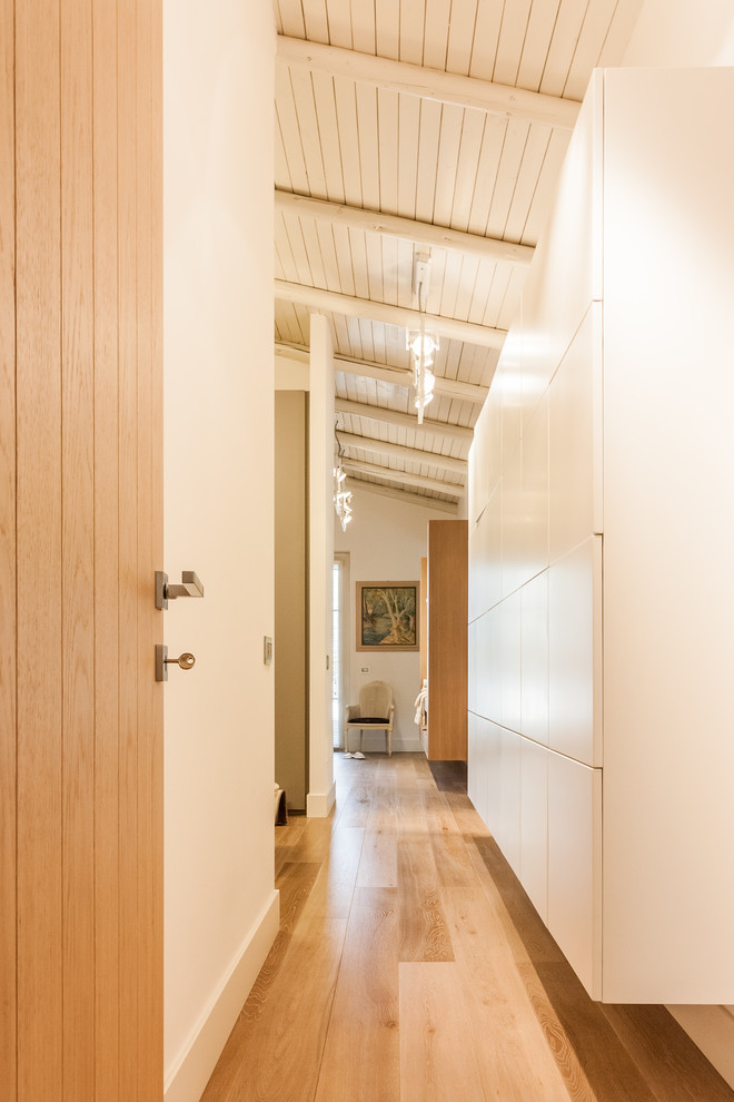 Hallway - large country medium tone wood floor and brown floor hallway idea in Other with beige walls