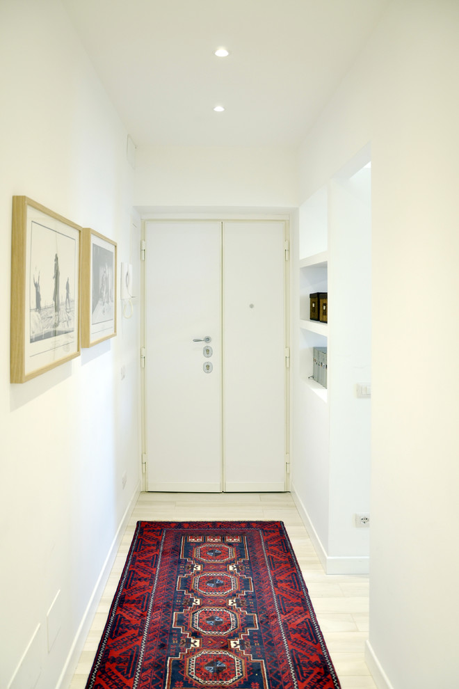 Immagine di un ingresso o corridoio contemporaneo di medie dimensioni con pareti bianche, parquet chiaro, una porta a due ante e una porta bianca