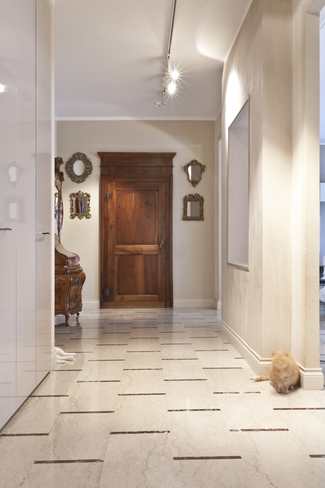 Cette photo montre une grande entrée éclectique avec un couloir, un mur beige, un sol en marbre et un sol beige.