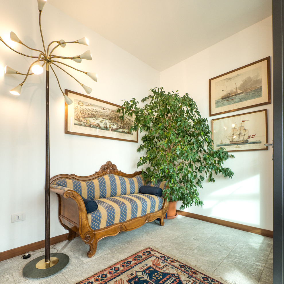This is an example of a medium sized bohemian boot room in Milan with white walls, limestone flooring, a single front door and a glass front door.