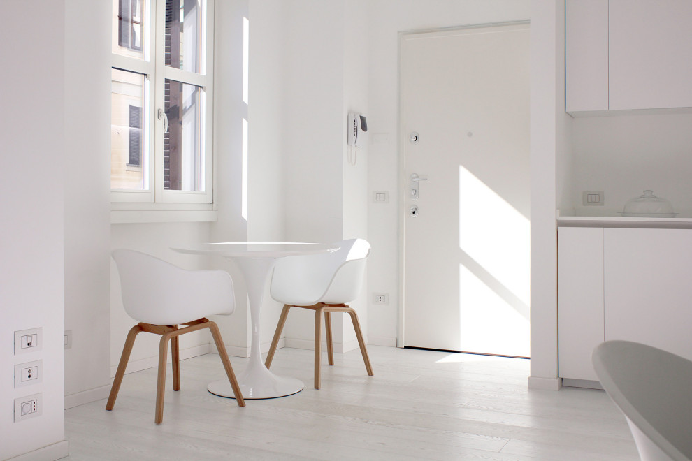 Inspiration for a small scandi front door in Milan with white walls, light hardwood flooring, a single front door, a white front door and white floors.