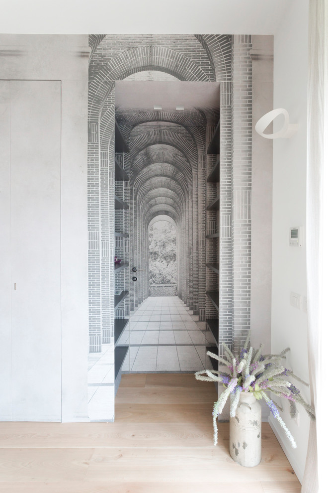 Aménagement d'un vestibule contemporain de taille moyenne avec un mur blanc, parquet clair, une porte simple, une porte en bois clair et un sol beige.