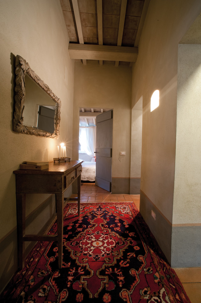 Esempio di un piccolo ingresso o corridoio country con pareti beige e pavimento in mattoni