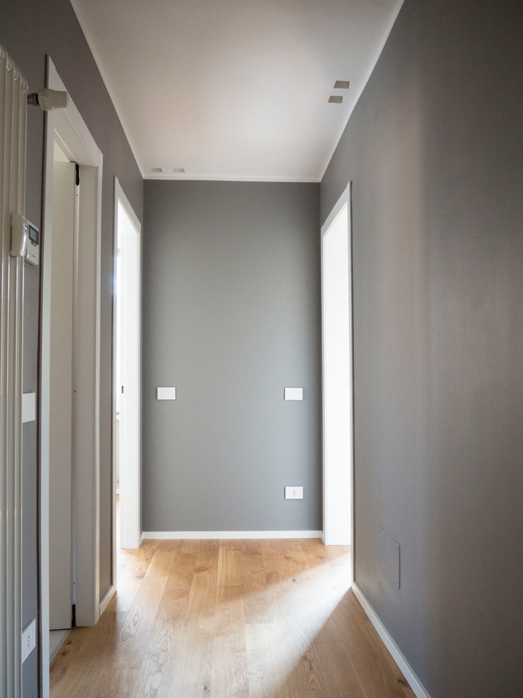 На фото: коридор среднего размера в современном стиле с серыми стенами и светлым паркетным полом с