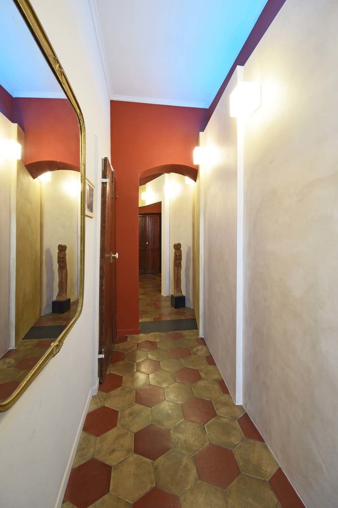 Idee per un grande ingresso o corridoio boho chic con pareti rosse, pavimento in terracotta e pavimento multicolore