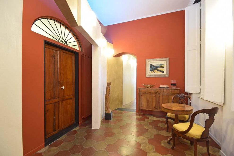 Immagine di un grande ingresso o corridoio eclettico con pareti rosse, pavimento in terracotta e pavimento multicolore