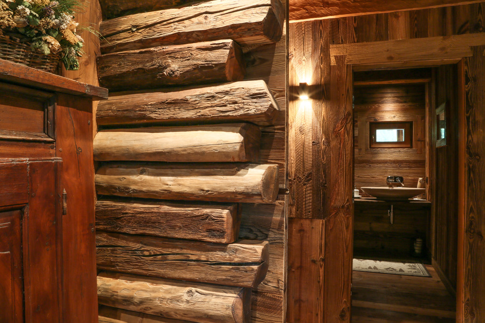 Idée de décoration pour un couloir chalet avec un mur marron et un sol en bois brun.