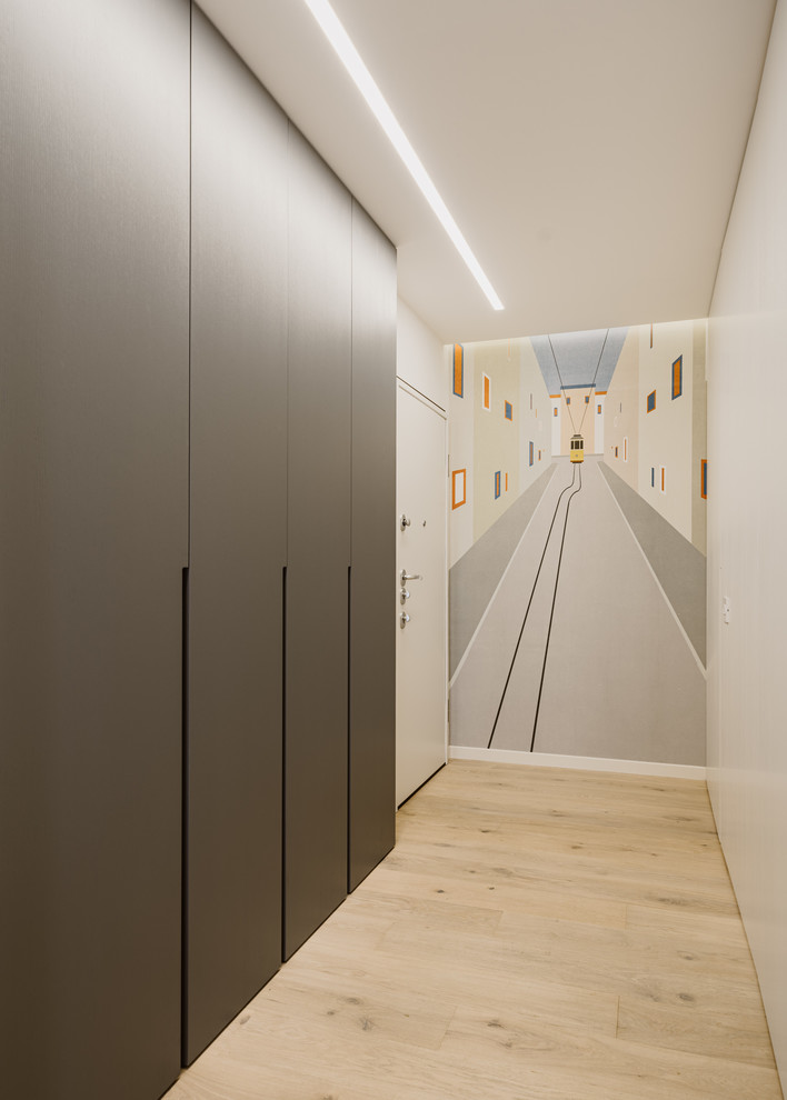 Réalisation d'un hall d'entrée minimaliste avec un mur blanc, parquet clair, une porte simple, une porte blanche et un sol beige.