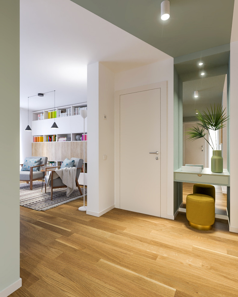 Inspiration pour une entrée design de taille moyenne avec un couloir, un mur vert, parquet clair, une porte simple et une porte blanche.