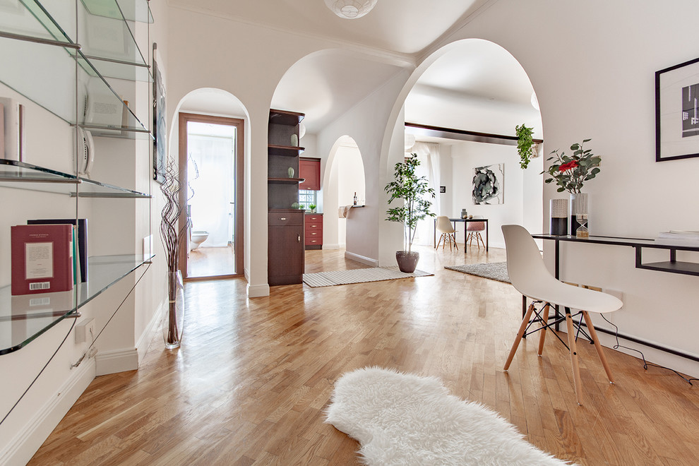 Esempio di un ingresso minimal con pareti bianche, pavimento in legno massello medio e pavimento marrone