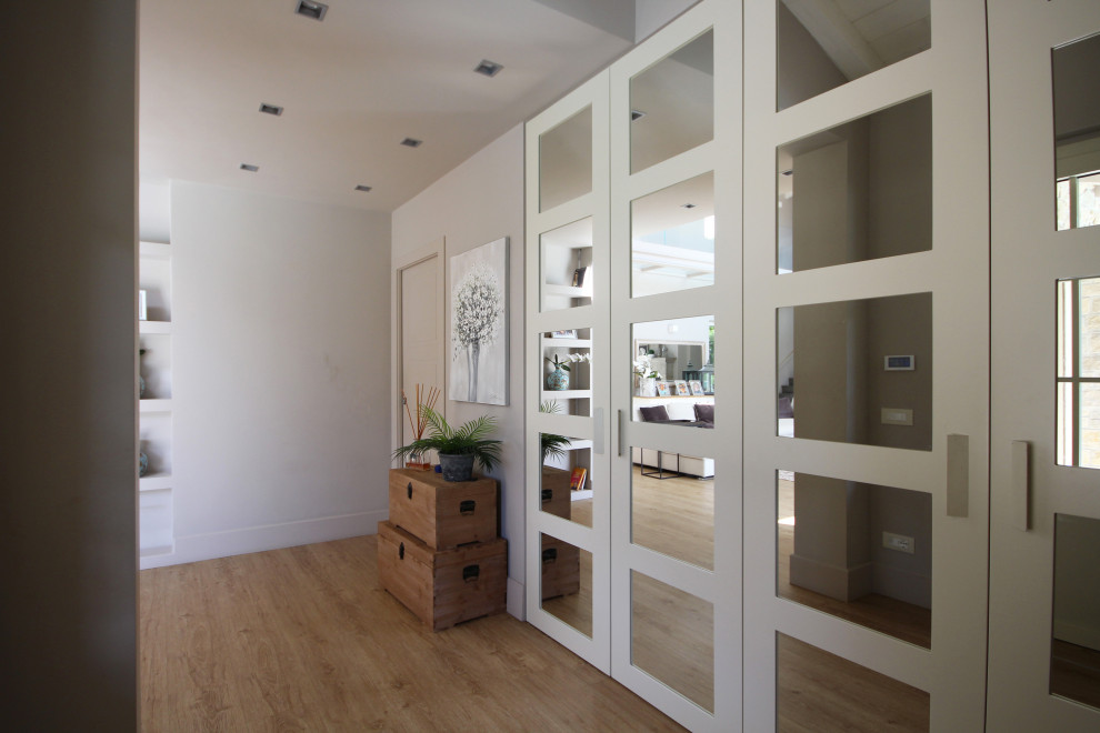 Geräumiges Country Foyer mit beiger Wandfarbe, braunem Holzboden, Schiebetür, weißer Haustür, braunem Boden, eingelassener Decke und Wandpaneelen in Mailand