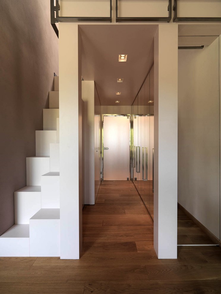 Großer Moderner Flur mit beiger Wandfarbe und braunem Holzboden in Turin