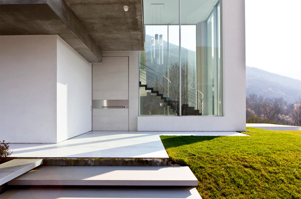 Ejemplo de entrada contemporánea de tamaño medio con paredes blancas, puerta simple y puerta blanca