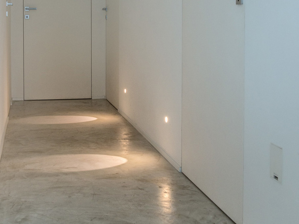На фото: коридор в современном стиле с белыми стенами и бетонным полом