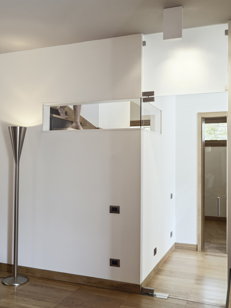 Hallway - mid-sized contemporary medium tone wood floor hallway idea in Turin with white walls