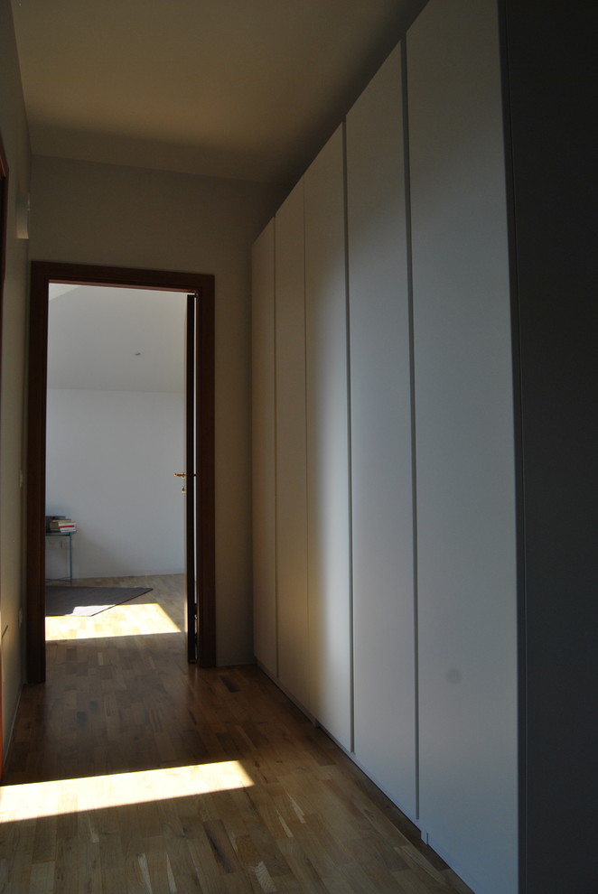 Immagine di un piccolo ingresso o corridoio design con pareti bianche, parquet chiaro e pavimento beige