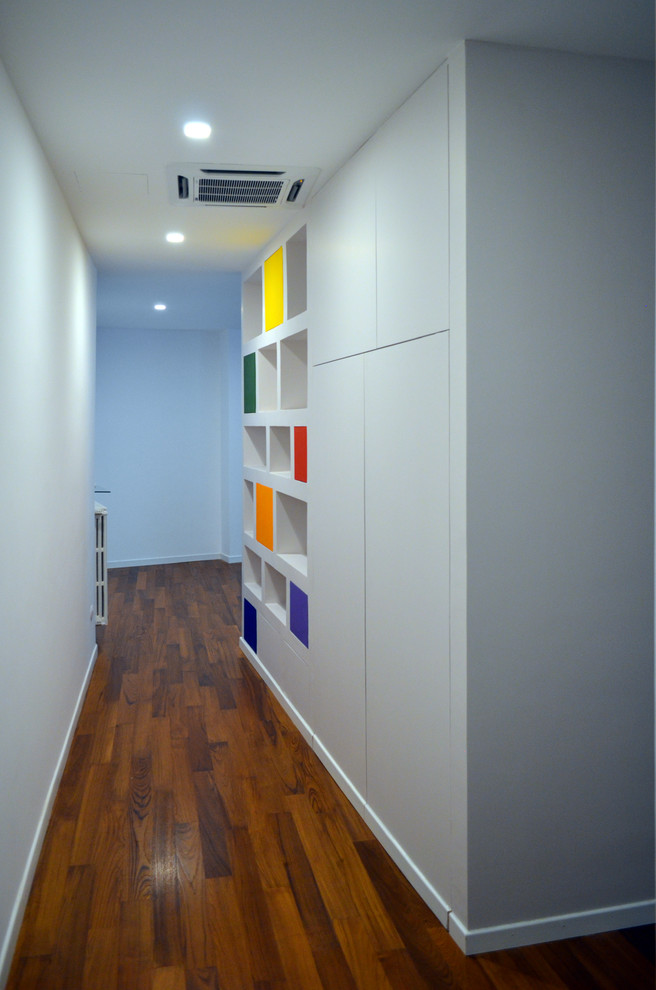 Cette photo montre un couloir moderne de taille moyenne avec un mur multicolore et parquet peint.