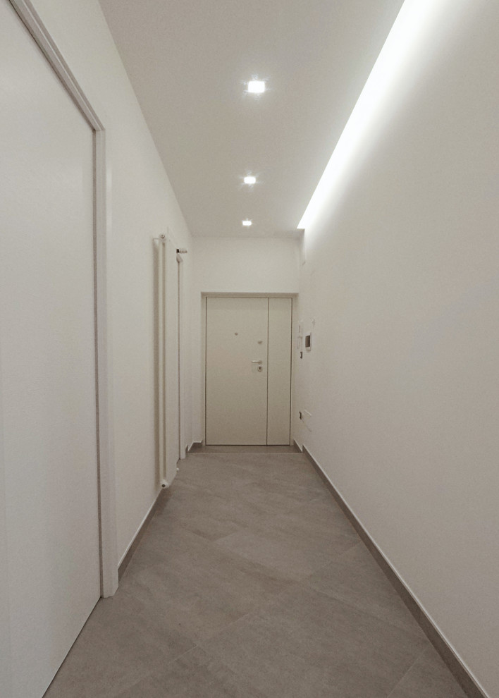 Esempio di un ingresso o corridoio design di medie dimensioni con pareti bianche, pavimento in gres porcellanato e pavimento grigio