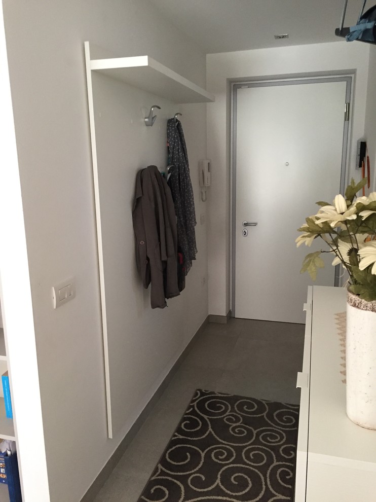 Esempio di un piccolo ingresso minimalista con pareti bianche, pavimento con piastrelle in ceramica e pavimento grigio