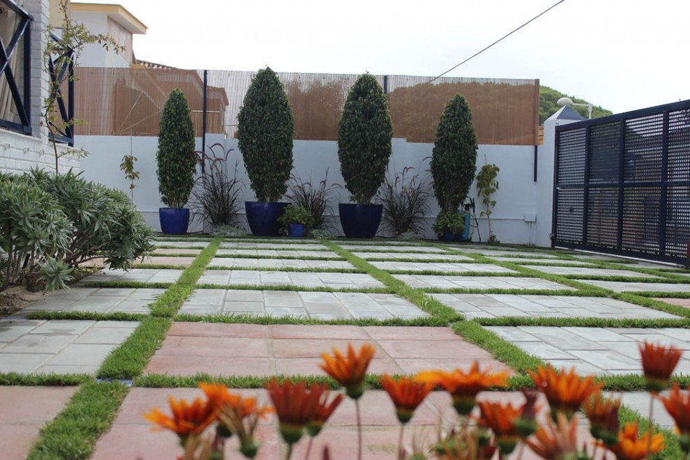 Réalisation d'un jardin arrière design de taille moyenne avec des pavés en béton.