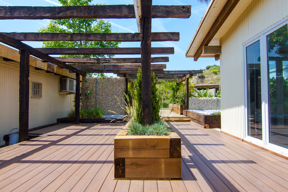 Großer, Halbschattiger Moderner Gartenweg im Frühling, hinter dem Haus mit Auffahrt und Dielen in Barcelona